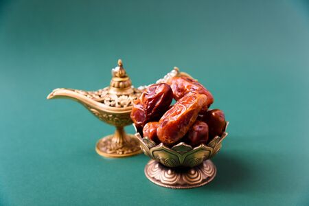 Ramadan, Dates in golden bowl, arabian Aladdin golden lamp vintage style on black green background