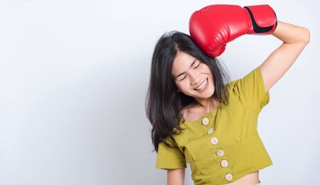 Portrait Asian beautiful young woman standing smile in boxing gloves and looking to camera, shoot the photo in a studio on a white background, There was copy spaceの写真素材