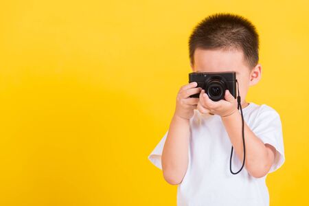 Asian Thai happy portrait cute little cheerful child boy hold photo camera compact doing taking the...