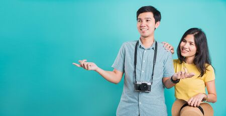 Happy Asian couple young beautiful woman handsome man smiling white teeth with camera in surprise summer holiday travel tourists isolated on blue background with copy space for textの写真素材