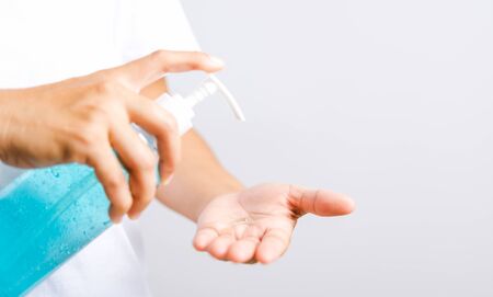 Closeup Hand Asian young woman applying pump dispenser sanitizer alcohol gel on hand wash cleaning, hygiene prevention COVID-19 or coronavirus protection concept, isolated on white backgroundの写真素材