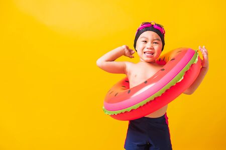 Summer vacation concept, Portrait Asian happy cute little child boy wear goggles and swimsuit hold...