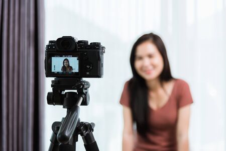 Work from home. Smiling Happy Asian young beautiful woman blogger with professional digital...