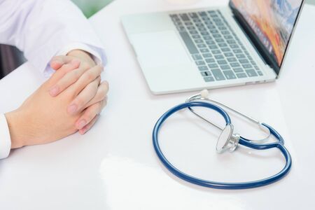 Medicine doctor's working on desk. Closeup of Stethoscope. Physician man video call sit hand in hand...