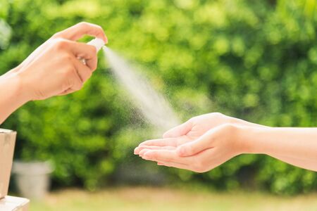 Asian delivery express courier young man use spray sterilize before giving boxes to woman customer...