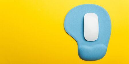 Top view flat lay of blue pad or mousepad with wireless white computer mouse modern design isolated...
