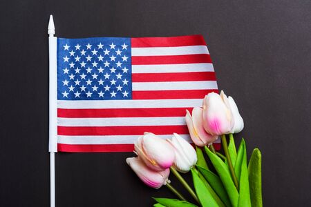 Happy Memorial Day Remember previously but now seldom called Decoration Day, American flag and a Tulip flower on a black background and copy space, a federal holiday in the United Statesの写真素材