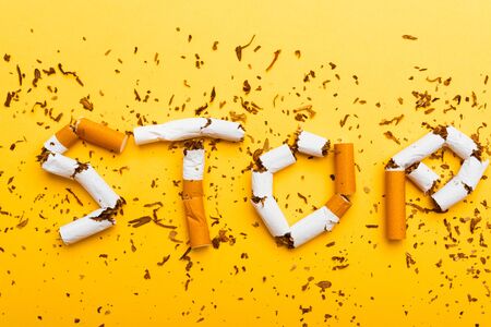 31 May of World No Tobacco Day, no smoking close up word STOP spelled text of the pile cigarette or tobacco on yellow background with copy space, and Warning lung health conceptの写真素材