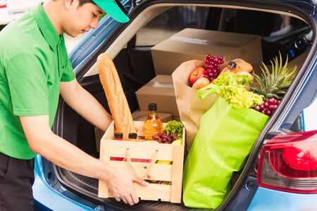 Asian delivery man grocery prepare service giving fresh vegetables food and fruit full in wooden...