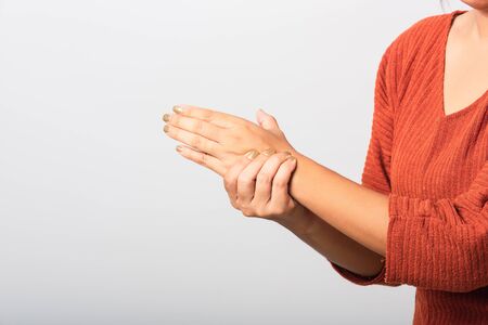 Close up hand of Asian woman she holding her acute pain in wrist of hands, studio shot isolated on white background, Healthcare medicine arthritis body care symptomatic office syndrome conceptの写真素材