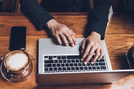 Young businesswoman is working by typing on his computer laptop in a coffee shopの写真素材
