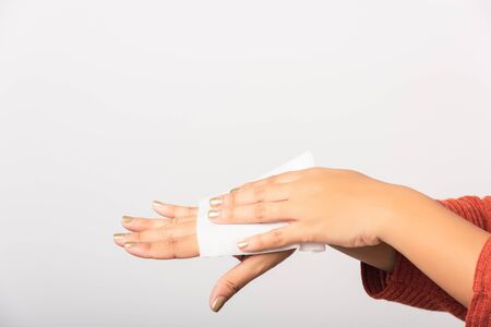 Close up hand of Asian woman she using wet tissue paper wipe cleaning her hands, studio shot isolated on white background, Healthcare medicine body care conceptの写真素材