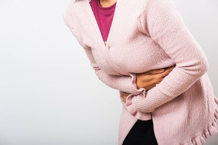 Asian woman sick have stomach ache holds hands on abdomen, part of body, female having painful...