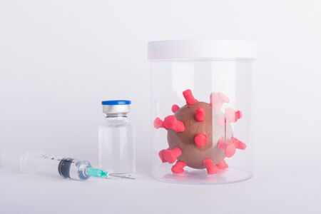 Closeup plasticine disease cells virus bottle vaccine and syringe of coronavirus outbreak and coronaviruses influenza flu, studio shot isolated on white background, pandemic COVID-19 medical healthの写真素材