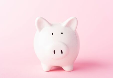 Front small white fat piggy bank, studio shot isolated on pink background and copy space for use, Finance, deposit saving money conceptの写真素材