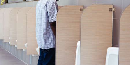 The man peeing in male toilet urinals bowl in restroom, wcの写真素材
