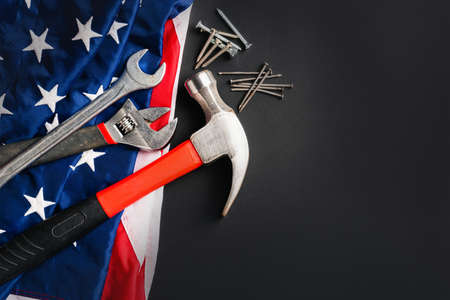 Labor day concept, Top view flat lay of different kinds wrenches with American flag on black. First...