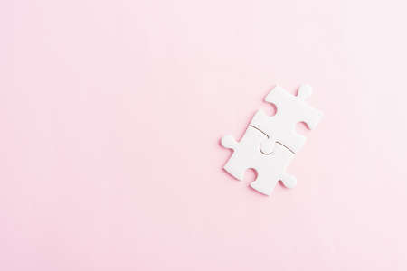Top view flat lay of two paper plain white jigsaw puzzle game last pieces for solve, studio shot on a pink background, quiz calculation conceptの写真素材