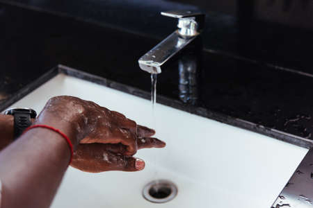 Closeup washing black man hands rubbing with soap and water in sinks to prevent outbreak coronavirus...