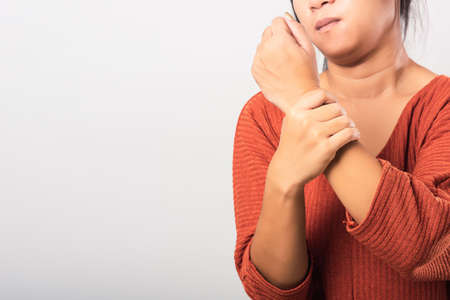 Close up hand of Asian woman she holding her acute pain in wrist of hands, studio shot isolated on white background, Healthcare medicine arthritis body care symptomatic office syndrome conceptの写真素材