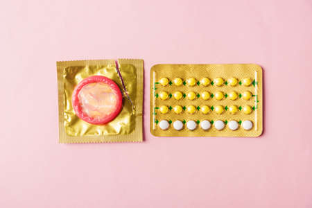 World sexual health or Aids day, condom on wrapper pack and contraceptive pills blister hormonal...