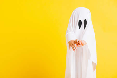 Funny Halloween Kid Concept, Closeup a little cute child with white dressed costume halloween ghost...