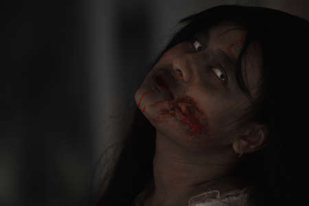 Girl zombie in blood. Closeup face and eyes of Asian Woman ghost with blood. Horror creepy scary...