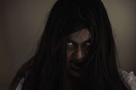 Girl zombie in blood. Closeup face and eyes of Asian Woman ghost with blood. Horror creepy scary...