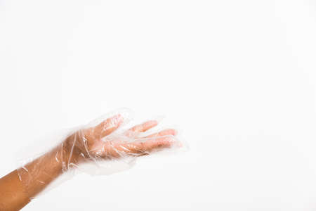 Woman hand wearing single use protect disposable transparent plastic glove, studio shot isolated on white backgroundの写真素材