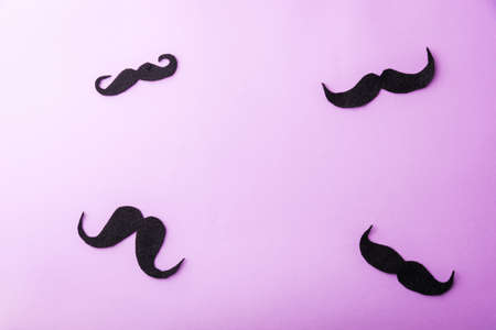 Black mustache paper, studio shot isolated on purple background, Prostate cancer awareness month, Fathers day, minimal November moustache conceptの写真素材