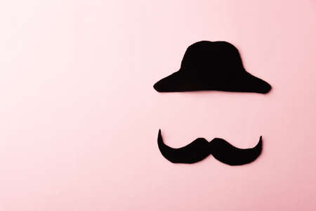 Black mustache and cap, studio shot isolated on pink background, Prostate cancer awareness month, Fathers day, minimal November moustache conceptの写真素材