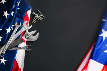 Labor day concept, Top view flat lay of different kinds wrenches with American flag on black. First Monday in September, creation of labor movement and dedicated to social of the American workerの写真素材