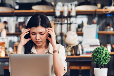 Freelance business woman working with laptop computer he was stressed out with job failing bankruptcy in coffee shopの写真素材