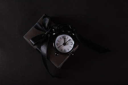 Black Friday sale shopping concept, Top view of gift box wrapped in black paper and black bow ribbon...