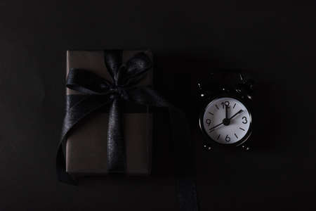 Black Friday sale shopping concept, Top view of gift box wrapped in black paper and black bow ribbon...
