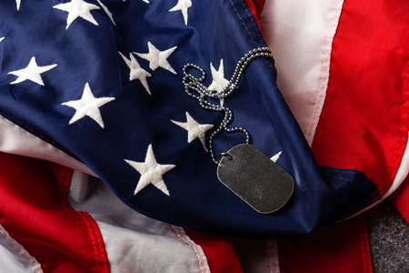America United States flag and chain dog tags, military symbolizing, studio shot on concrete board...
