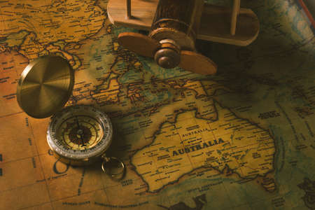 Old compass discovery and wooden plane on vintage paper antique world map background, Retro style...