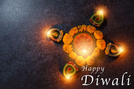 Top view overhead clay lit light a fire already on Diya or oil lamp and flower, studio shot on...