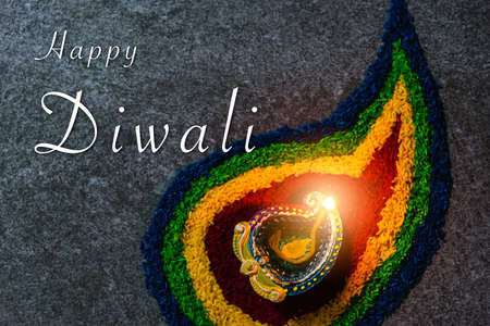 Close up clay lit light a fire already on Diya or oil lamp on concrete background, Decoration of Hinduism rangoli, Happy celebration Deepavali, or Diwali Indian festival conceptの写真素材