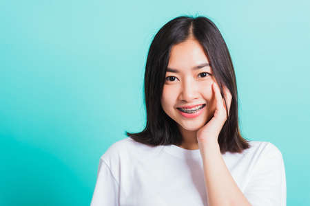 Portrait of Asian teen beautiful young woman smile have dental braces on teeth laughing she touching...
