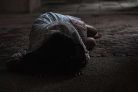 Girl zombie in blood. Asian Woman ghost with blood. Horror scary fear in dark house creepy crawling move slowly creeping out. Hair covering face her eye looking to camera, Halloween festival conceptの写真素材