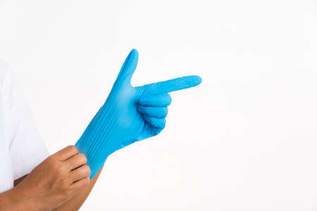 Woman wearing and putting hand to blue rubber latex glove for doctor with thumb pointing finger...