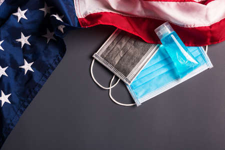 Medical protective disposable face mask for cover mouth and America flag, studio shot on gray...