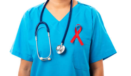 Woman nurse in clinic uniform with support HIV AIDS awareness red ribbon on the chest in studio shot isolated on over white background, Healthcare and medicine, World aids day conceptの写真素材