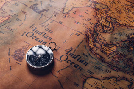 Old compass discovery on vintage paper antique world map background, Retro style cartography travel...