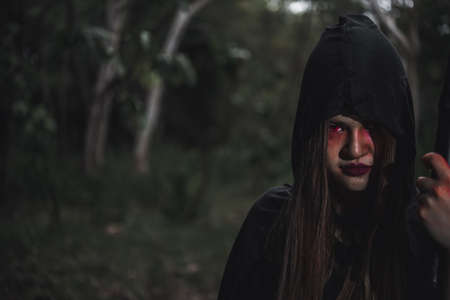 Woman ghost horror her have scythe on hand in forest, halloween day conceptの写真素材