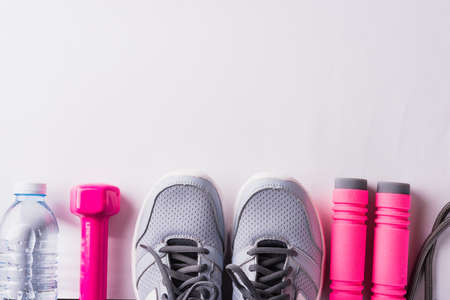 Pair sports shoes, headphones, dumbbell and water bottle on white background, Gray sneakers and accessories equipment in fitness GYM, Healthy workout active lifestyle diet conceptの写真素材