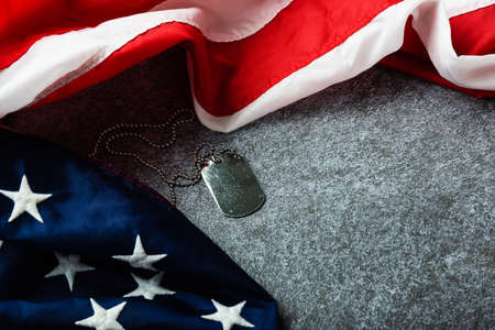 America United States flag and chain dog tags, military symbolizing, studio shot on concrete board background, US Veterans or Independence day conceptの写真素材