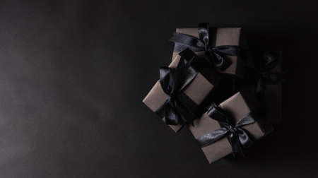 Black Friday sale shopping concept, Top view of gift box wrapped in black paper and black bow...