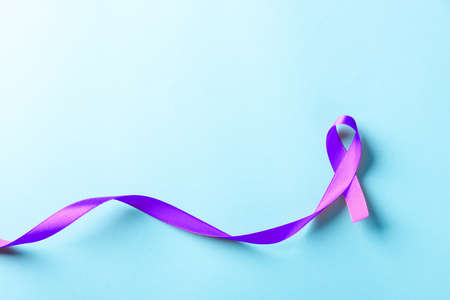 National Epilepsy or Alzheimer disease Day Concept. Purple ribbon symbol of Pancreatic cancer awareness and world Lupus Day and world cancer isolated blue backgroundの写真素材